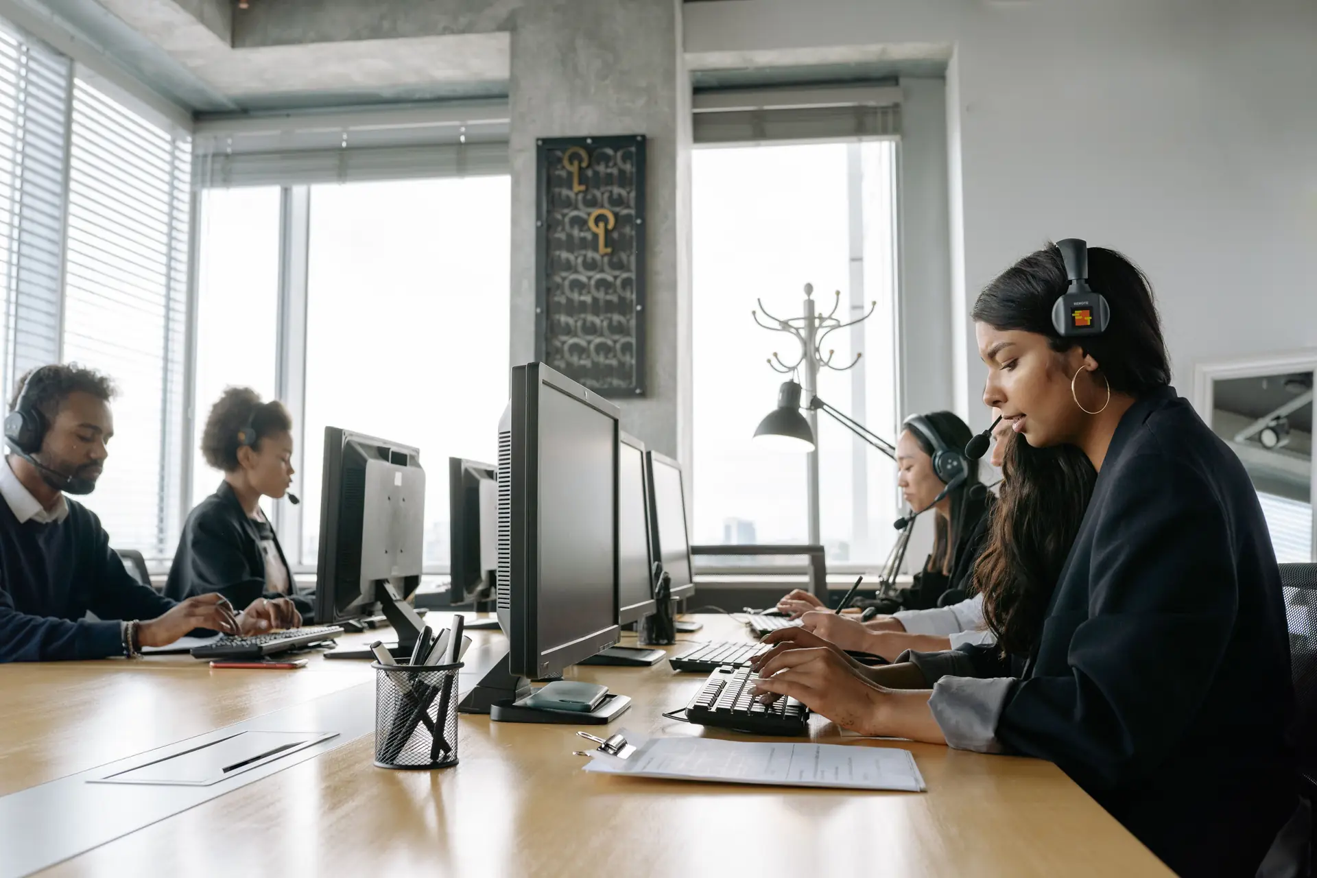 Persone con le cuffie al computer in un ufficio di assistenza clienti